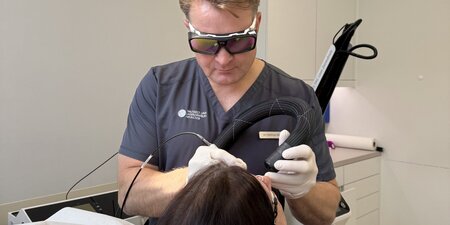 Dr. Matthias Wahn bei einer Laserbehandlung mit Schutzbrille